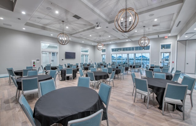 13402 SW Sorella Dr, Port Saint Lucie, FL 34987 - dining area with a chandelier, light wood-style floors, coffered ceiling, a high ceiling, and a tray ceiling
