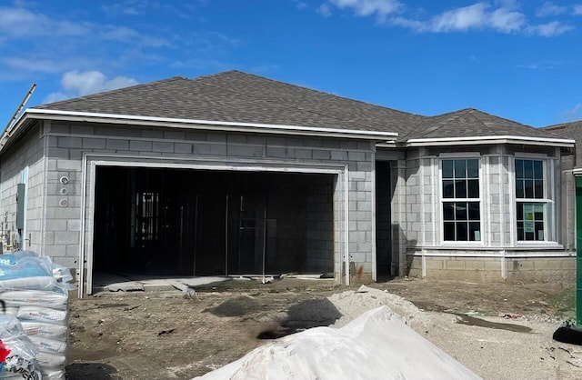 exterior space with a garage and roof with shingles