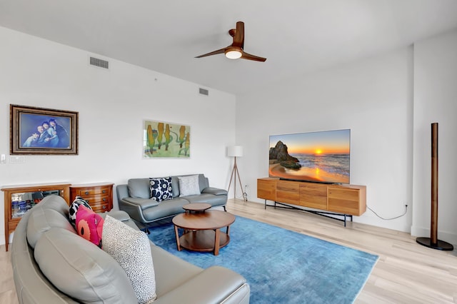 living room featuring ceiling fan, visible vents, and wood finished floors