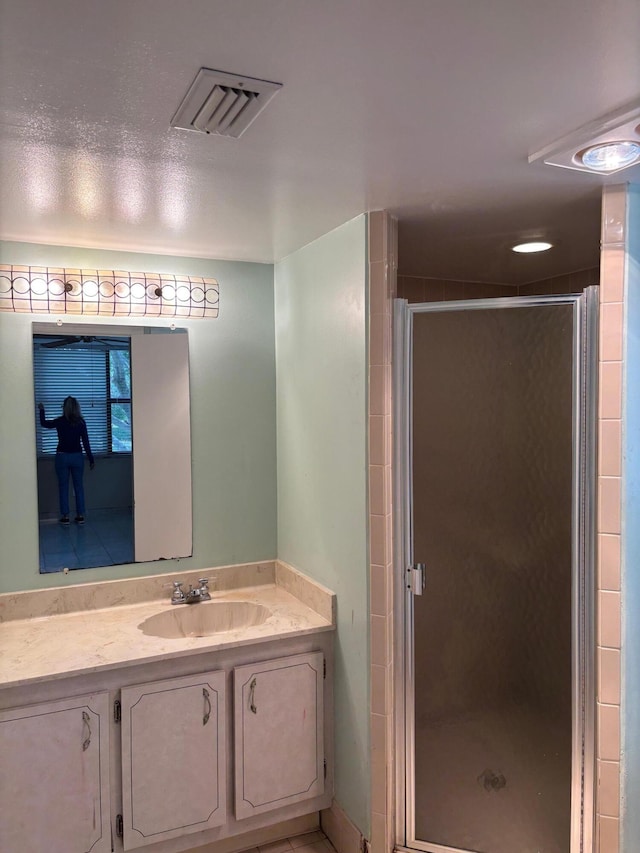 full bath with visible vents, a shower stall, and vanity