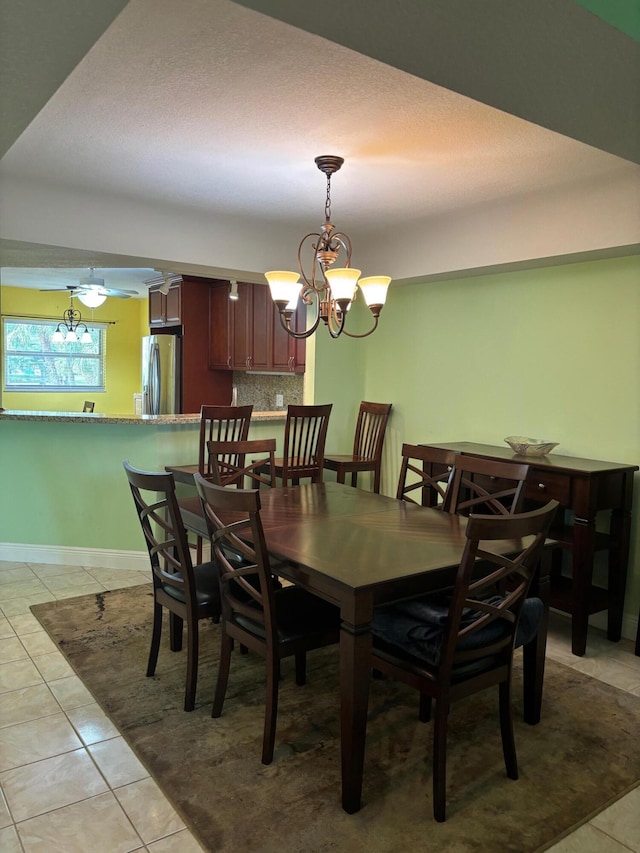 dining room with a chandelier, light tile patterned floors, and baseboards