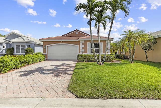 view of front of house with a garage, a tile roof, decorative driveway, stucco siding, and a front yard