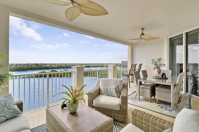 balcony with a water view, ceiling fan, outdoor lounge area, and outdoor dining space