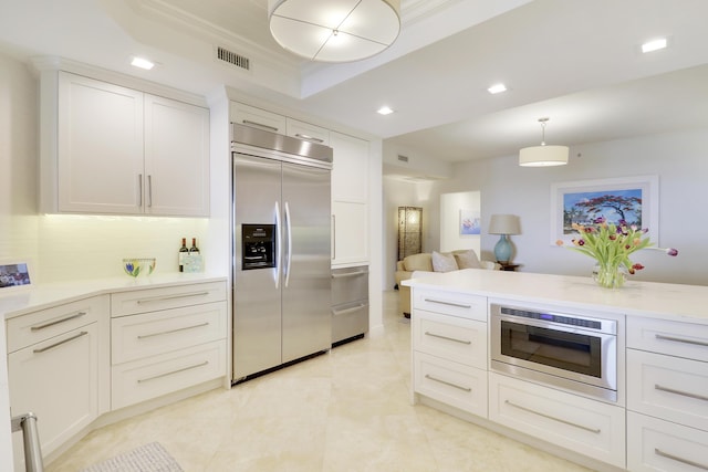 kitchen featuring visible vents, white cabinets, hanging light fixtures, a tray ceiling, and stainless steel built in refrigerator