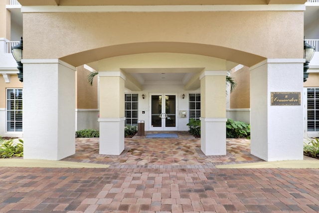 view of exterior entry with french doors and stucco siding