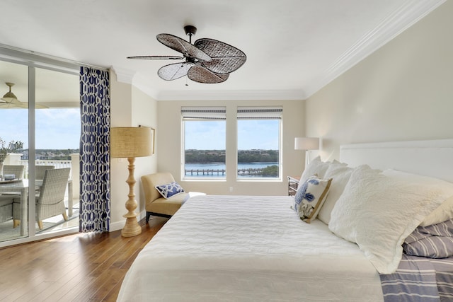 bedroom with a water view, wood finished floors, access to outside, multiple windows, and crown molding