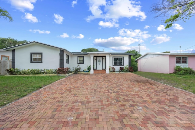 ranch-style home featuring a front yard and stucco siding