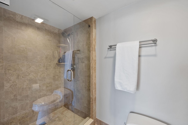 bathroom featuring a stall shower and toilet