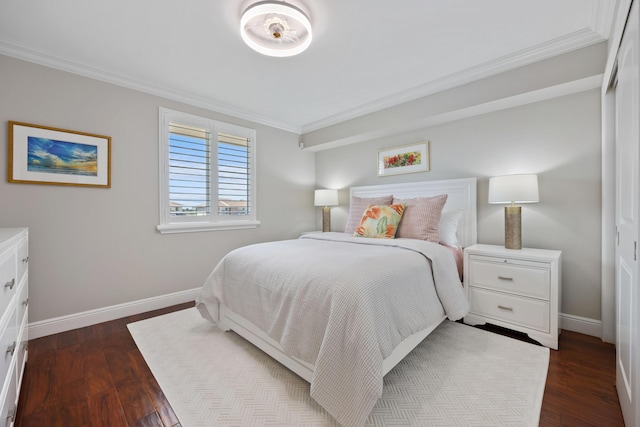 bedroom with dark wood-type flooring, ornamental molding, and baseboards