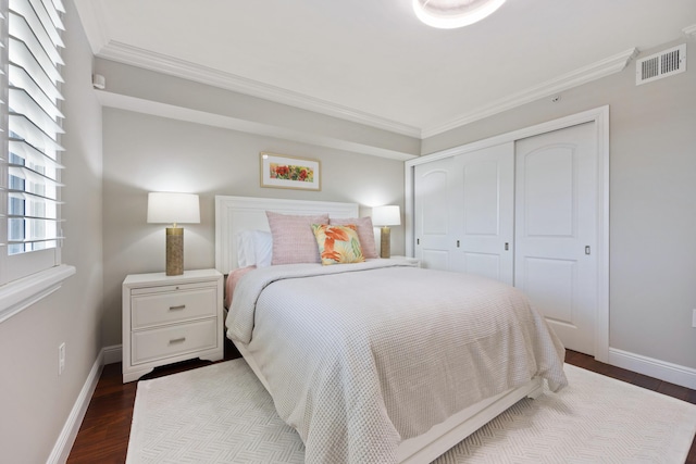 bedroom featuring dark wood-style flooring, crown molding, and baseboards