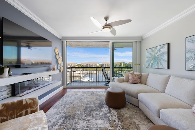 living room featuring ceiling fan, ornamental molding, and wood finished floors