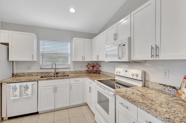 kitchen with white appliances, a sink, and white cabinetry