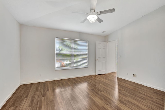 spare room with dark wood-type flooring, baseboards, and a ceiling fan