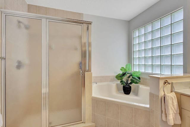 bathroom with a stall shower, a garden tub, and a wealth of natural light