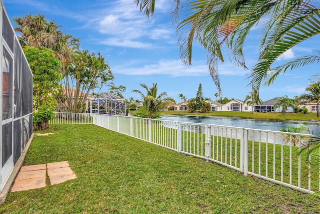 view of yard with a water view, glass enclosure, a fenced backyard, and a residential view