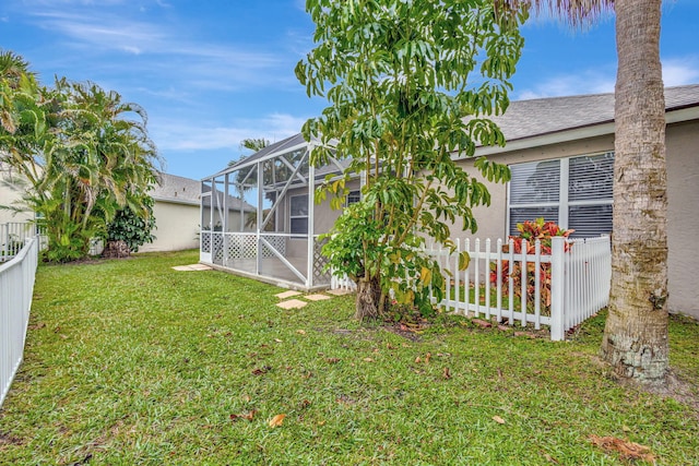 view of yard with glass enclosure and a fenced backyard