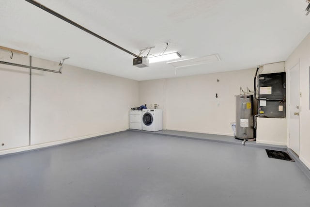 garage featuring heating unit, water heater, washer and clothes dryer, and a garage door opener