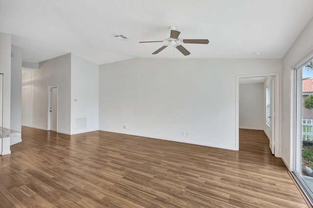 unfurnished room with visible vents, vaulted ceiling, and wood finished floors