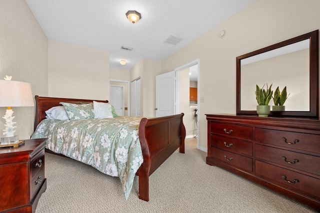 bedroom with a closet, light carpet, and visible vents