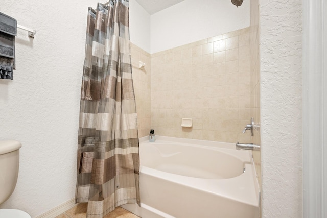 full bath featuring a textured wall, shower / bathtub combination with curtain, and toilet