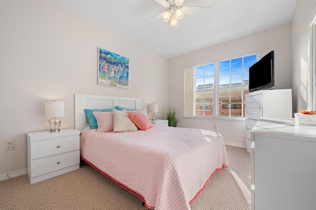 bedroom featuring light carpet, a ceiling fan, and baseboards