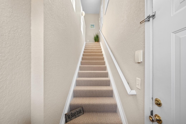 stairs featuring a textured wall