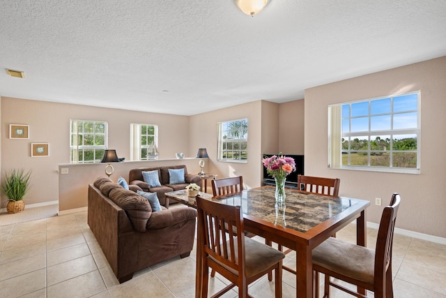 dining space with visible vents, a textured ceiling, baseboards, and light tile patterned flooring