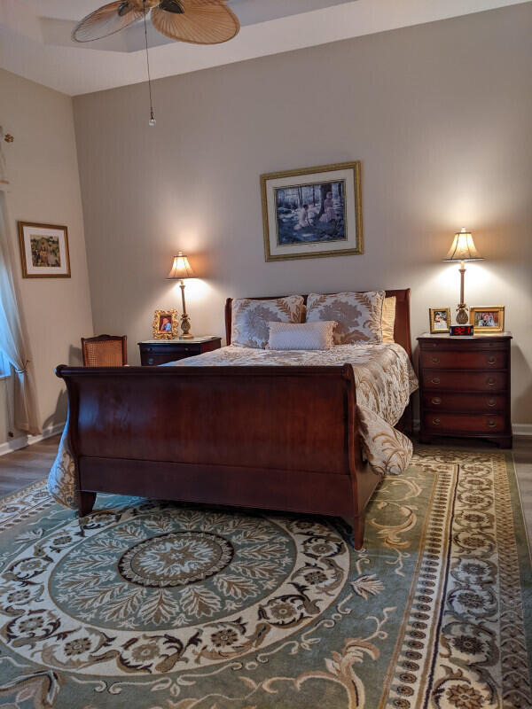 bedroom featuring ceiling fan, wood finished floors, and baseboards