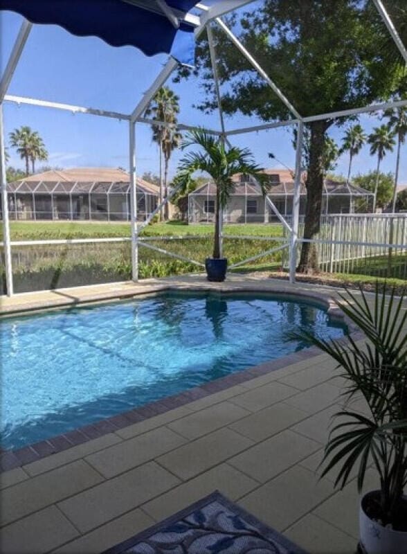 view of swimming pool featuring a lanai, fence, a fenced in pool, and a patio