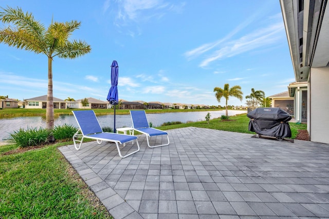 view of patio / terrace with grilling area, a water view, and a residential view