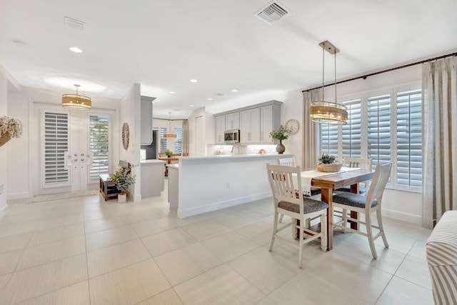 dining space with light tile patterned floors, visible vents, an inviting chandelier, french doors, and recessed lighting