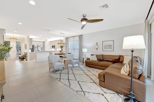 living area with ceiling fan, visible vents, a wealth of natural light, and recessed lighting