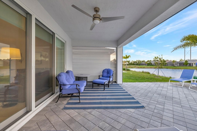 view of patio / terrace featuring a water view and a ceiling fan