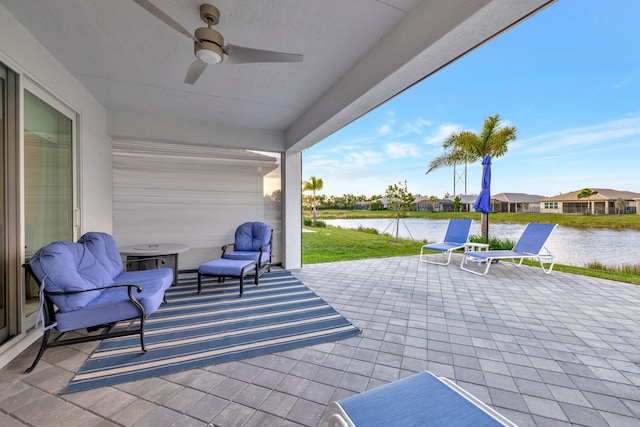 view of patio / terrace featuring a water view, a residential view, and a ceiling fan