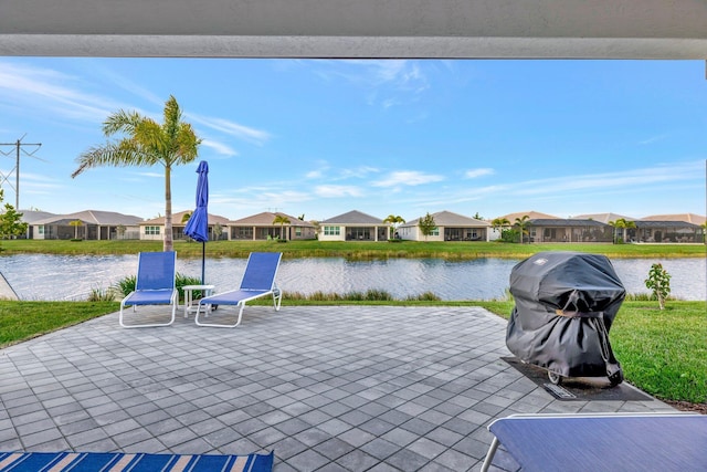 view of patio with a residential view, a water view, and grilling area