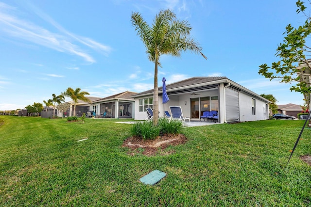 back of property with a yard, a patio, a ceiling fan, and stucco siding