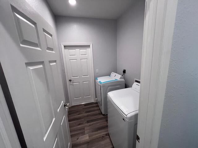 laundry area with laundry area, dark wood finished floors, and washer and dryer