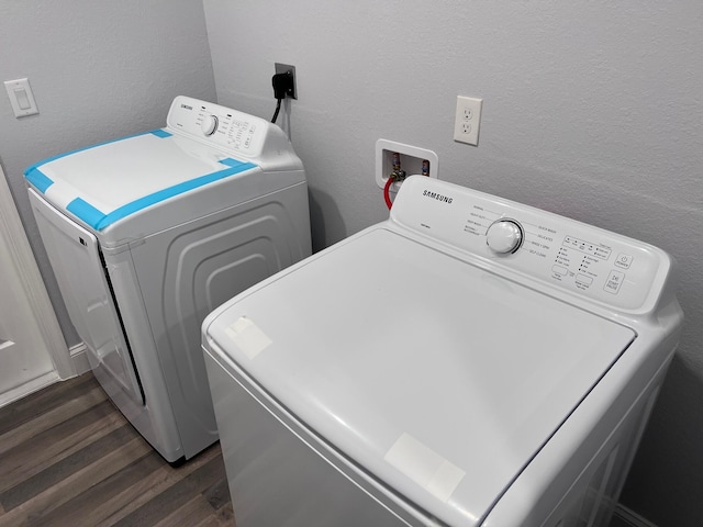 washroom with dark wood-style floors, a textured wall, laundry area, and independent washer and dryer