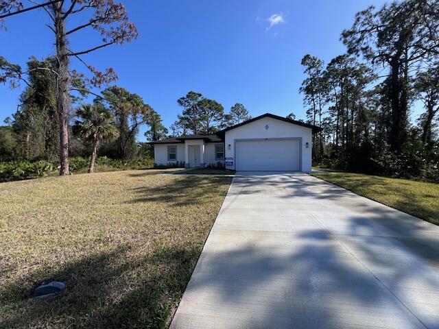 ranch-style house with concrete driveway, an attached garage, and a front yard