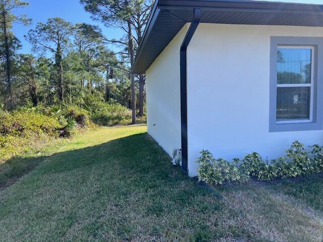 view of home's exterior with a yard and stucco siding