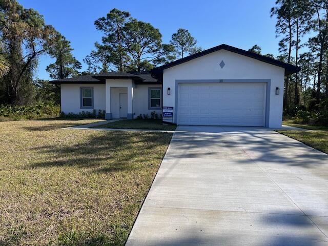 ranch-style home with a garage, a front lawn, concrete driveway, and stucco siding