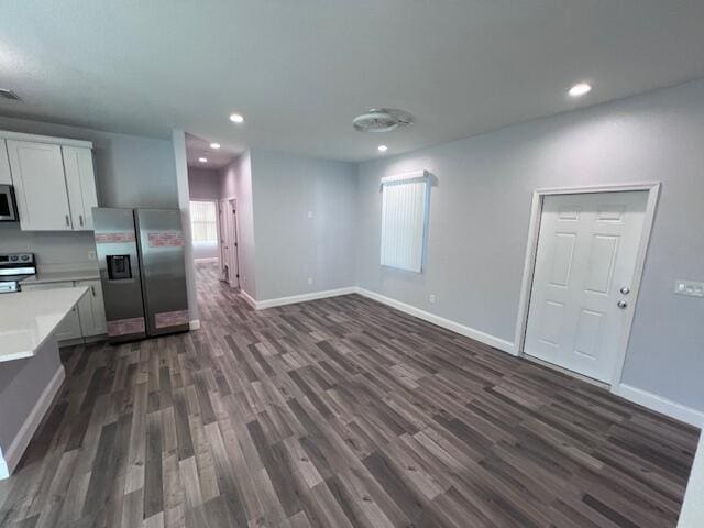 kitchen featuring dark wood-type flooring, white cabinetry, baseboards, light countertops, and appliances with stainless steel finishes