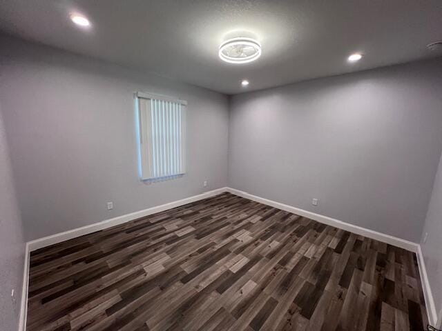 unfurnished room featuring recessed lighting, dark wood finished floors, and baseboards