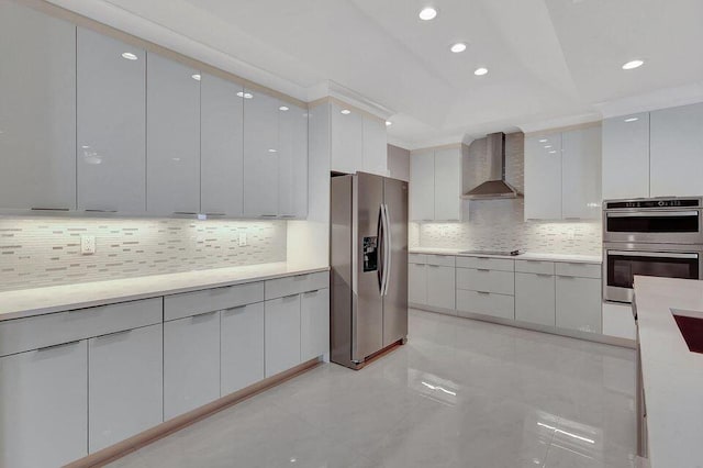 kitchen with stainless steel appliances, wall chimney range hood, and modern cabinets