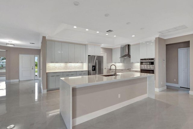 kitchen with stainless steel appliances, visible vents, a sink, wall chimney range hood, and modern cabinets