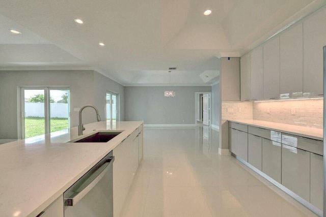 kitchen featuring decorative backsplash, dishwasher, light countertops, a sink, and recessed lighting