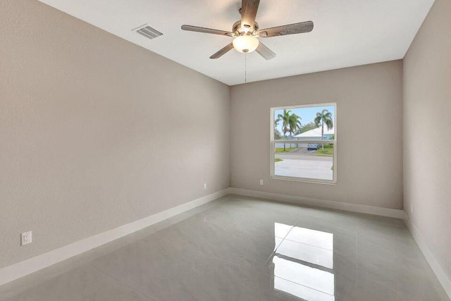 empty room with baseboards, visible vents, and ceiling fan