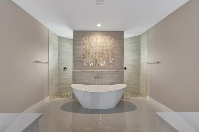 bathroom with a walk in shower, a soaking tub, tile patterned floors, and baseboards