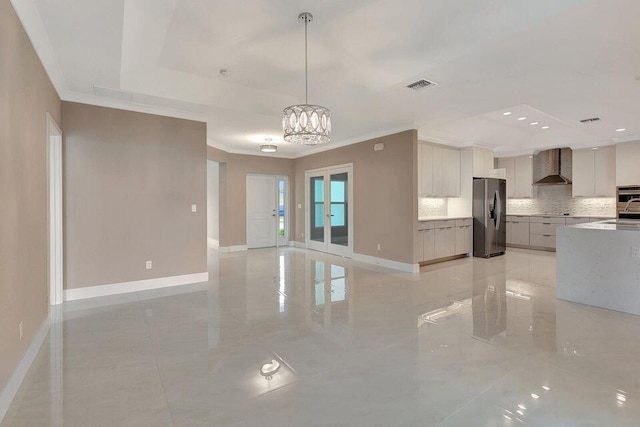 kitchen featuring wall chimney exhaust hood, modern cabinets, baseboards, and stainless steel appliances