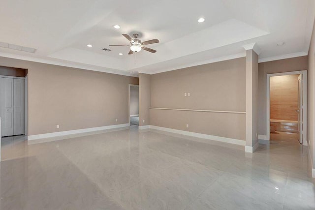 empty room with a tray ceiling, ceiling fan, baseboards, and recessed lighting